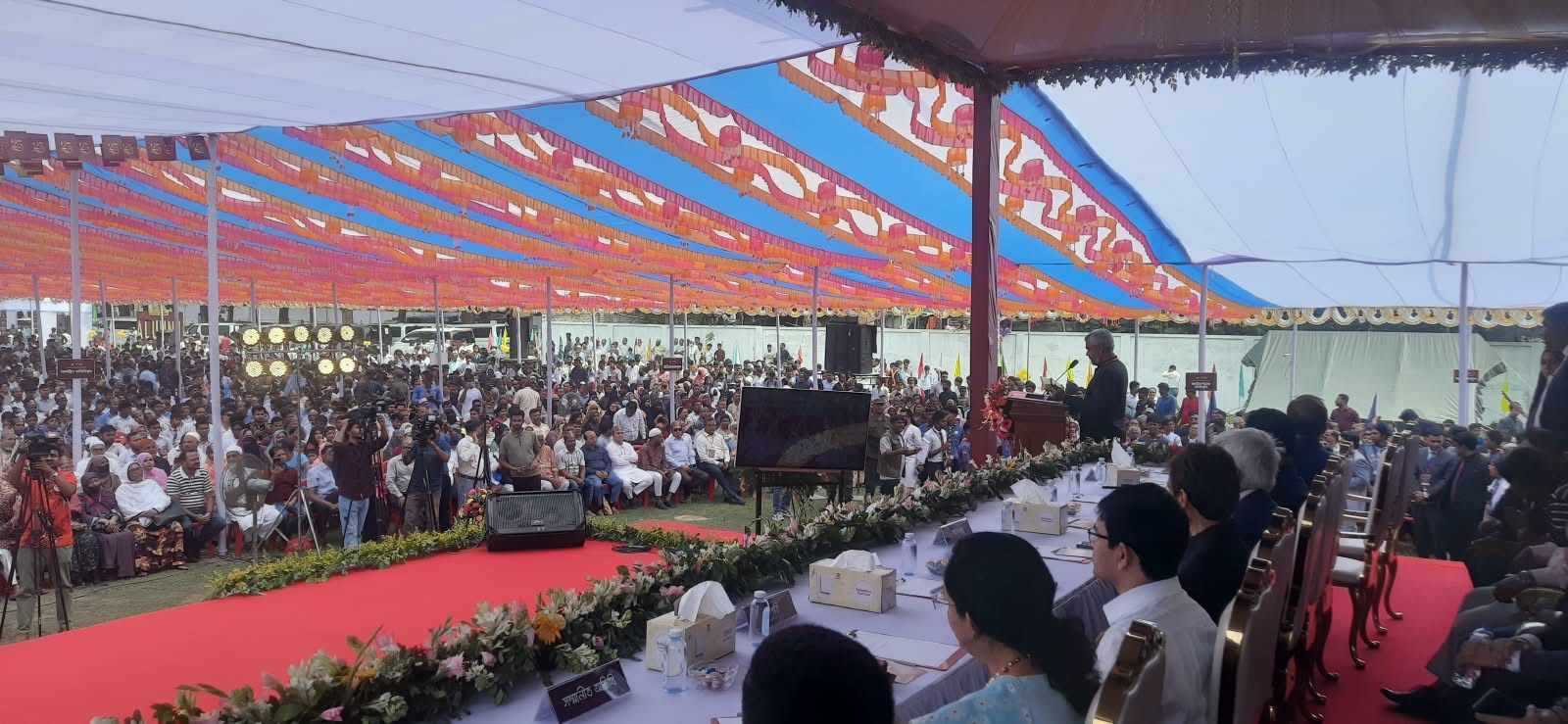 A speaker addressing the gathering from the stage.